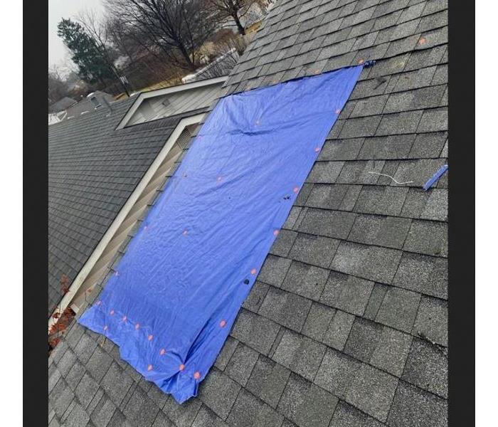 blue tarp on roof after tree went through roof