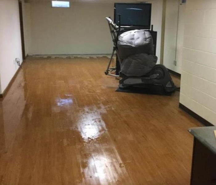 water damage on hardwood floor in residential basement 
